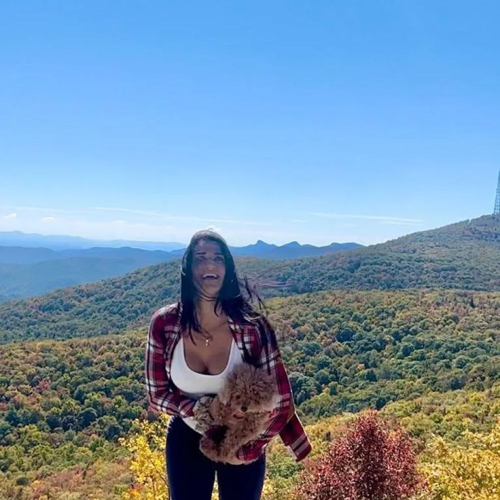 Woman with dog on a mountaintop.