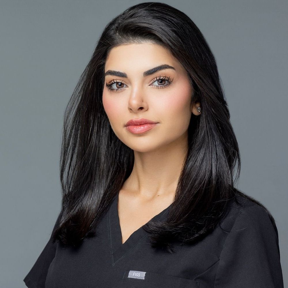 Professional woman in medical scrubs, confident expression.