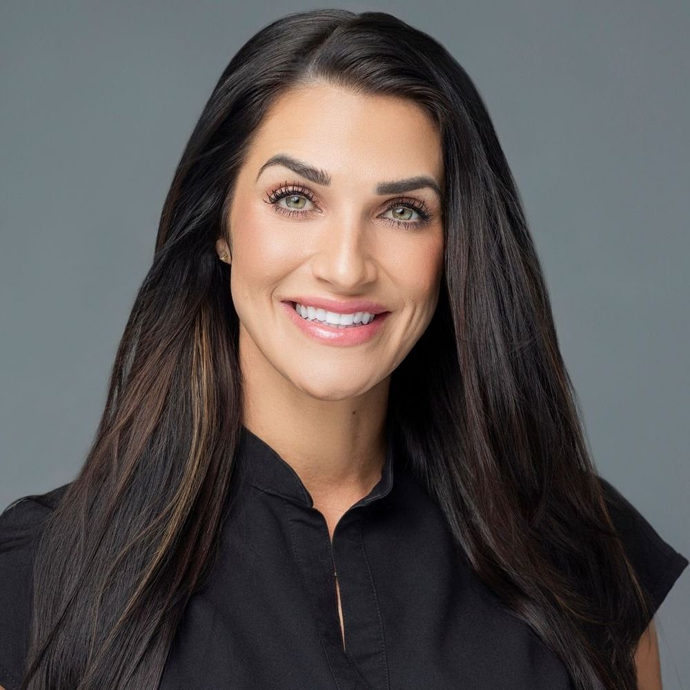 Smiling woman with long hair in black top.