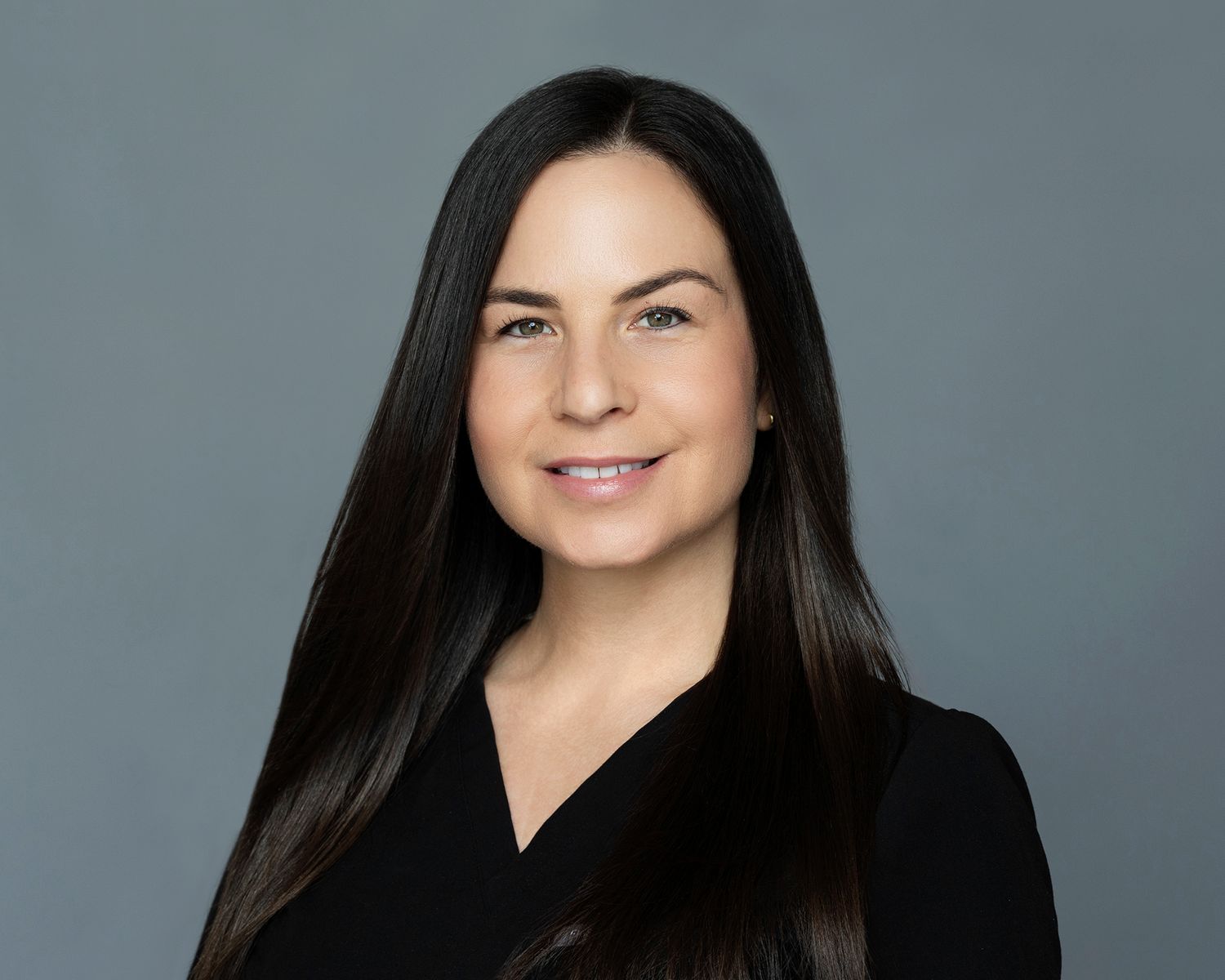 Woman in fitted top and black skirt posing.
