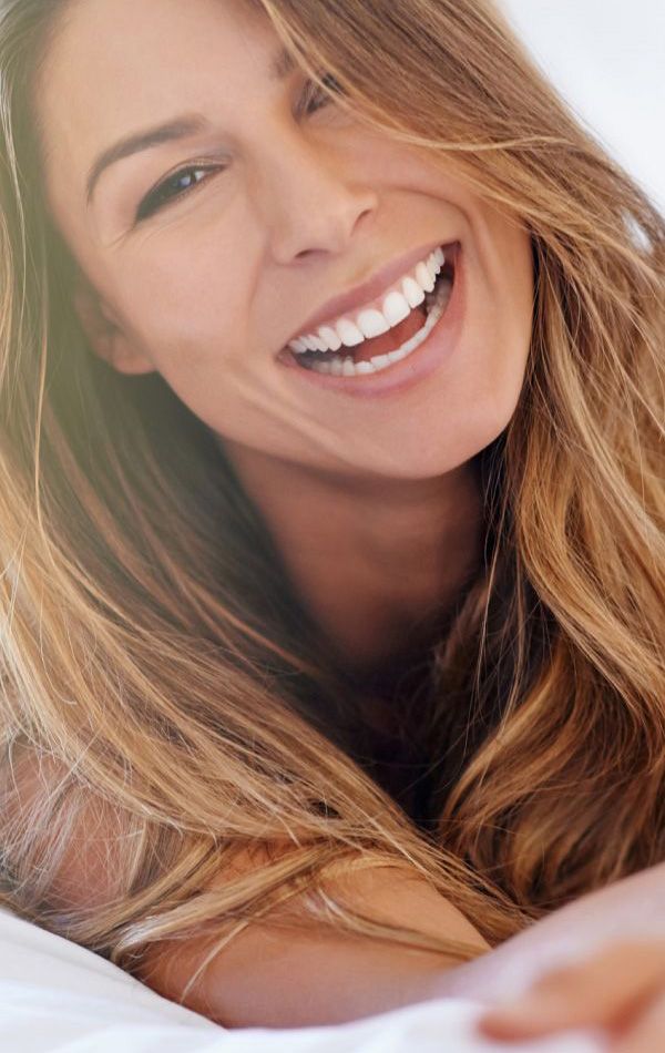 Smiling woman with long, wavy hair.