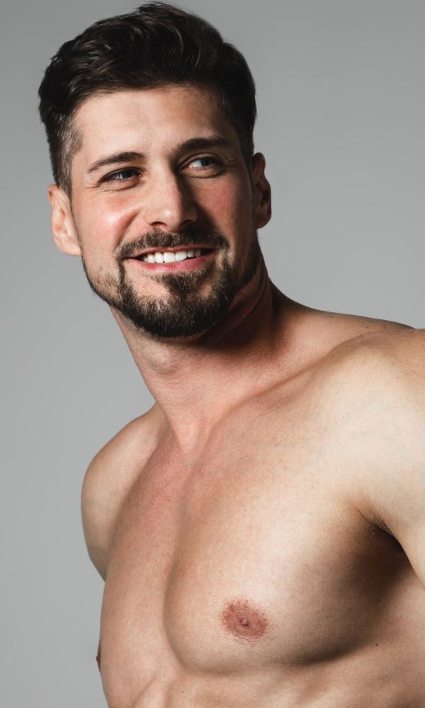 Smiling man with short hair, bare chest.