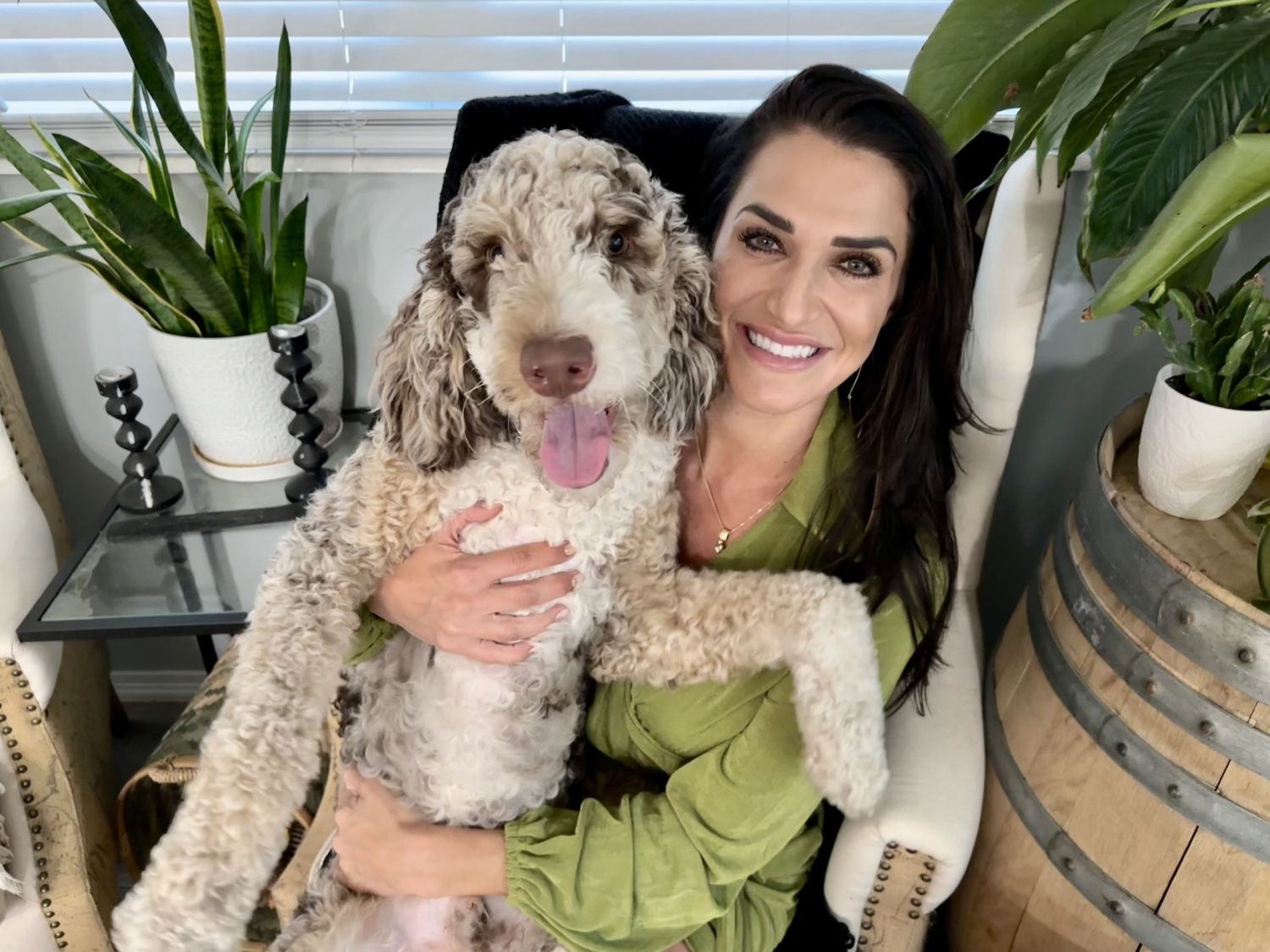 Woman holding a dog on a mountain overlook.