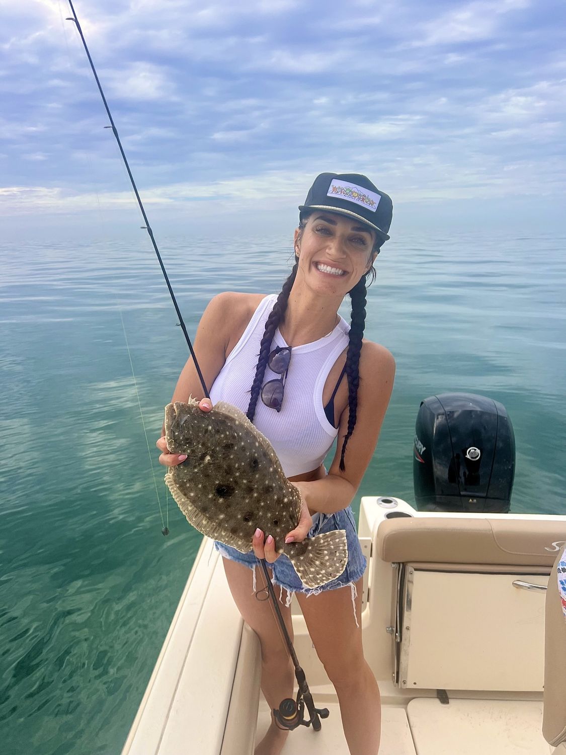 Smiling woman in car wearing a stylish outfit.