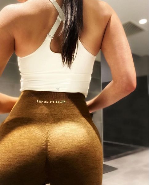 Woman in athletic wear posing in fitness studio.