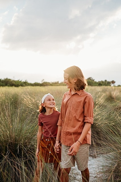 Children walking together in a grassy field.