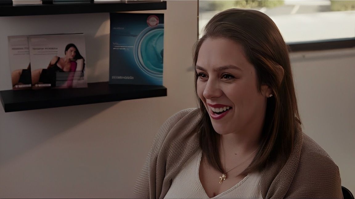 Smiling woman in consultation setting with brochures.