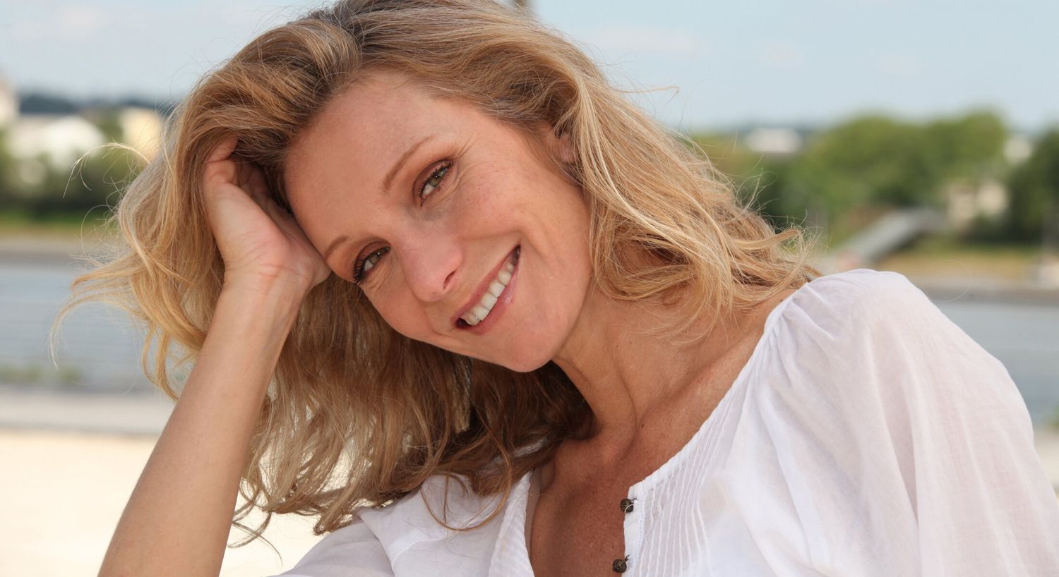 Smiling Tampa Xeomin model with flowing hair outdoors.